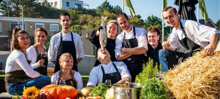 Een gezellige teamfoto van Restaurant Natuurlijk met een biologisch gevangen vis
